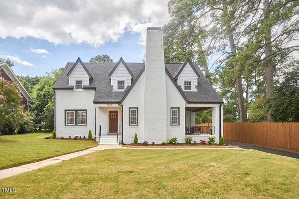 a front view of house with yard and trees around