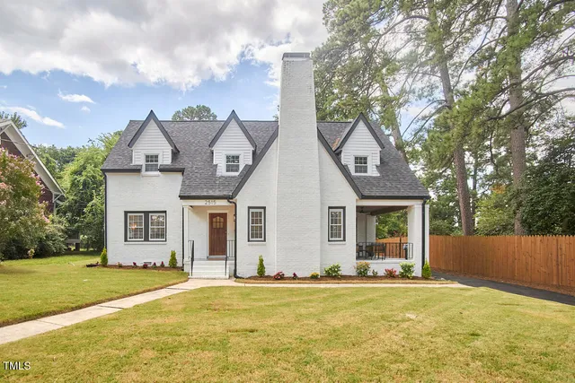 a front view of house with yard and trees around