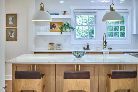 a kitchen with kitchen island a sink a stove and a window
