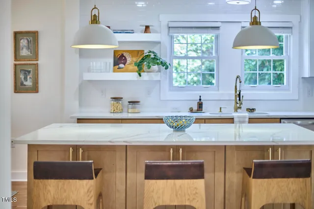 a kitchen with kitchen island a sink a stove and a window
