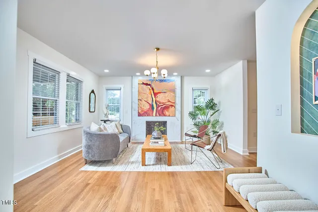 a living room with furniture a chandelier and a large window