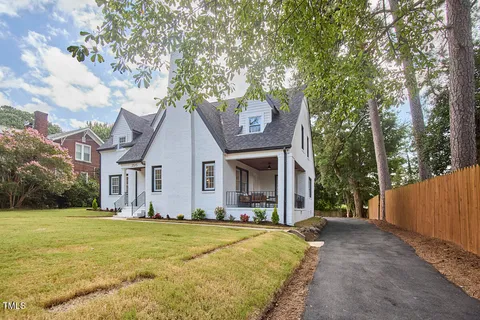 a front view of house with yard and trees around