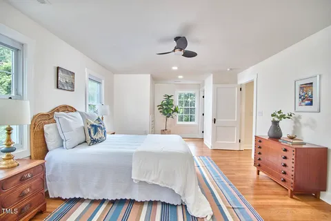a spacious bedroom with a large bed and a chandelier