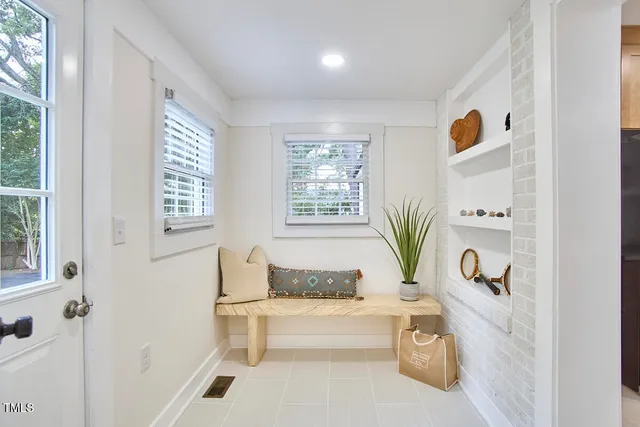 a bathroom with a sink a mirror and a potted plant