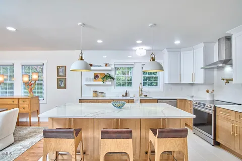 a kitchen with a table chairs sink and cabinets