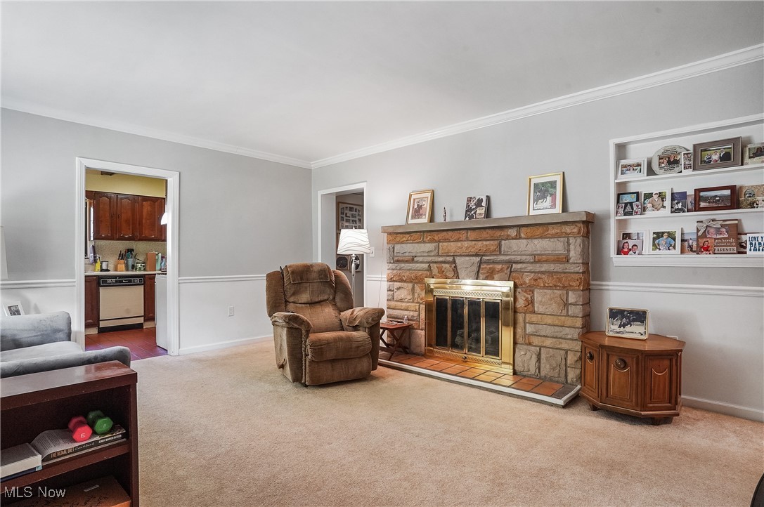 2829 Lee Road Silver Lake, OH 44224 - Photo 4 of 30 Sitting room featuring light carpet, ornamental molding, and a stone fireplace
