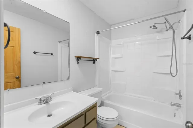 a bathroom with a bathtub shower sink vanity and toilet