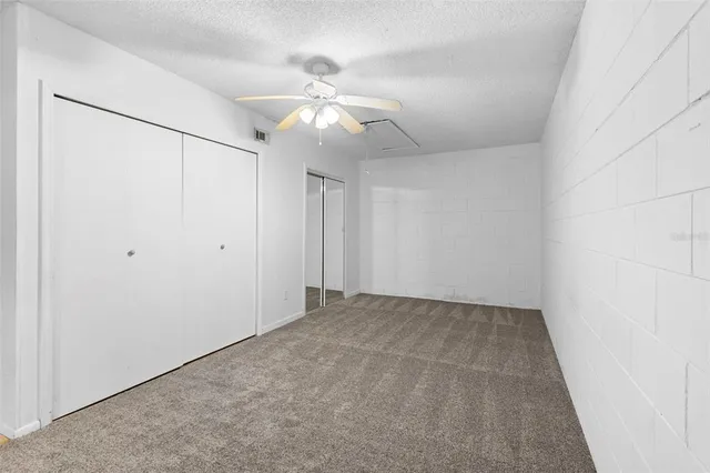 an empty room with a fan and a fan