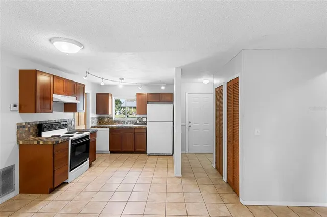a kitchen with stainless steel appliances granite countertop a refrigerator and a stove top oven