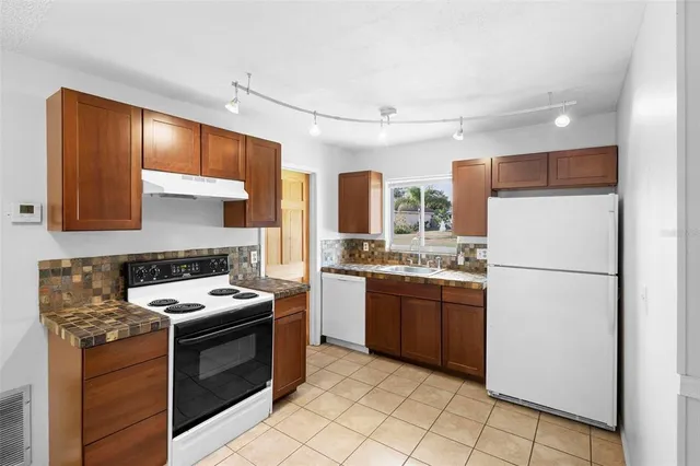 a kitchen with stainless steel appliances granite countertop a stove a refrigerator and a sink