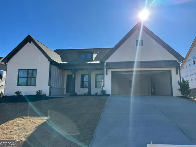 a view of a house with a yard and potted plants