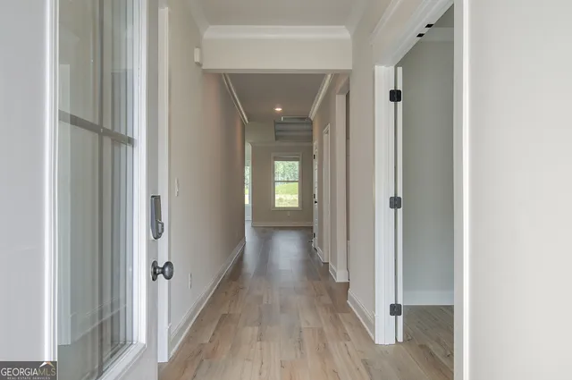 a view of an empty room with wooden floor fireplace and a window