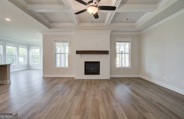 a view of an empty room with a kitchen and a window