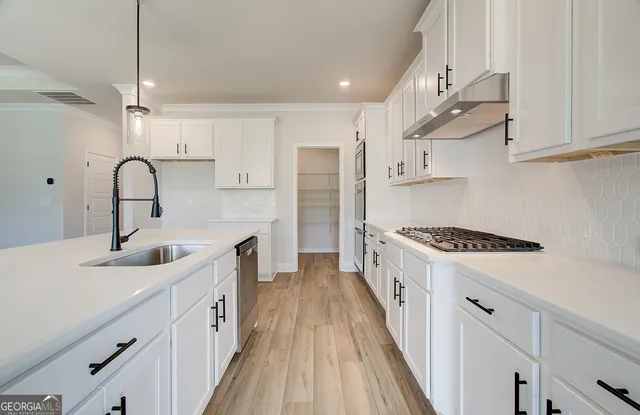 a kitchen with kitchen island a sink stove and wooden floor