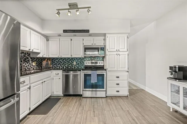 a kitchen with stainless steel appliances a stove sink and cabinets