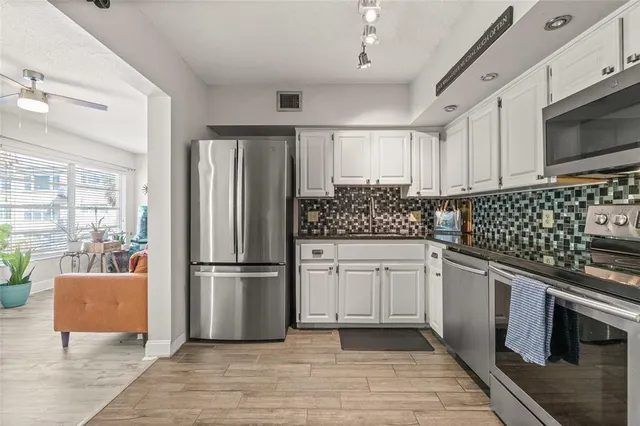 a kitchen with stainless steel appliances granite countertop a refrigerator sink and stove