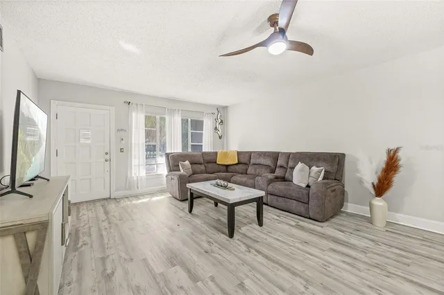 a living room with furniture a flat screen tv and a wooden floor