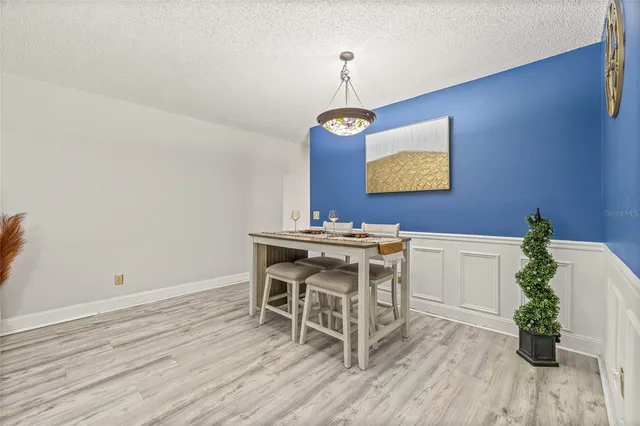 a dining room with furniture potted plants and wooden floor