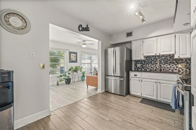 a kitchen with stainless steel appliances granite countertop a refrigerator and a stove top oven