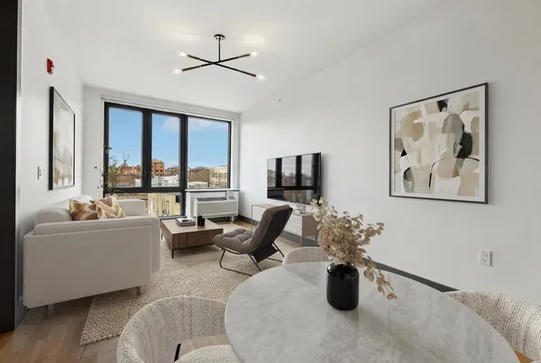 a living room with furniture potted plant and a large window