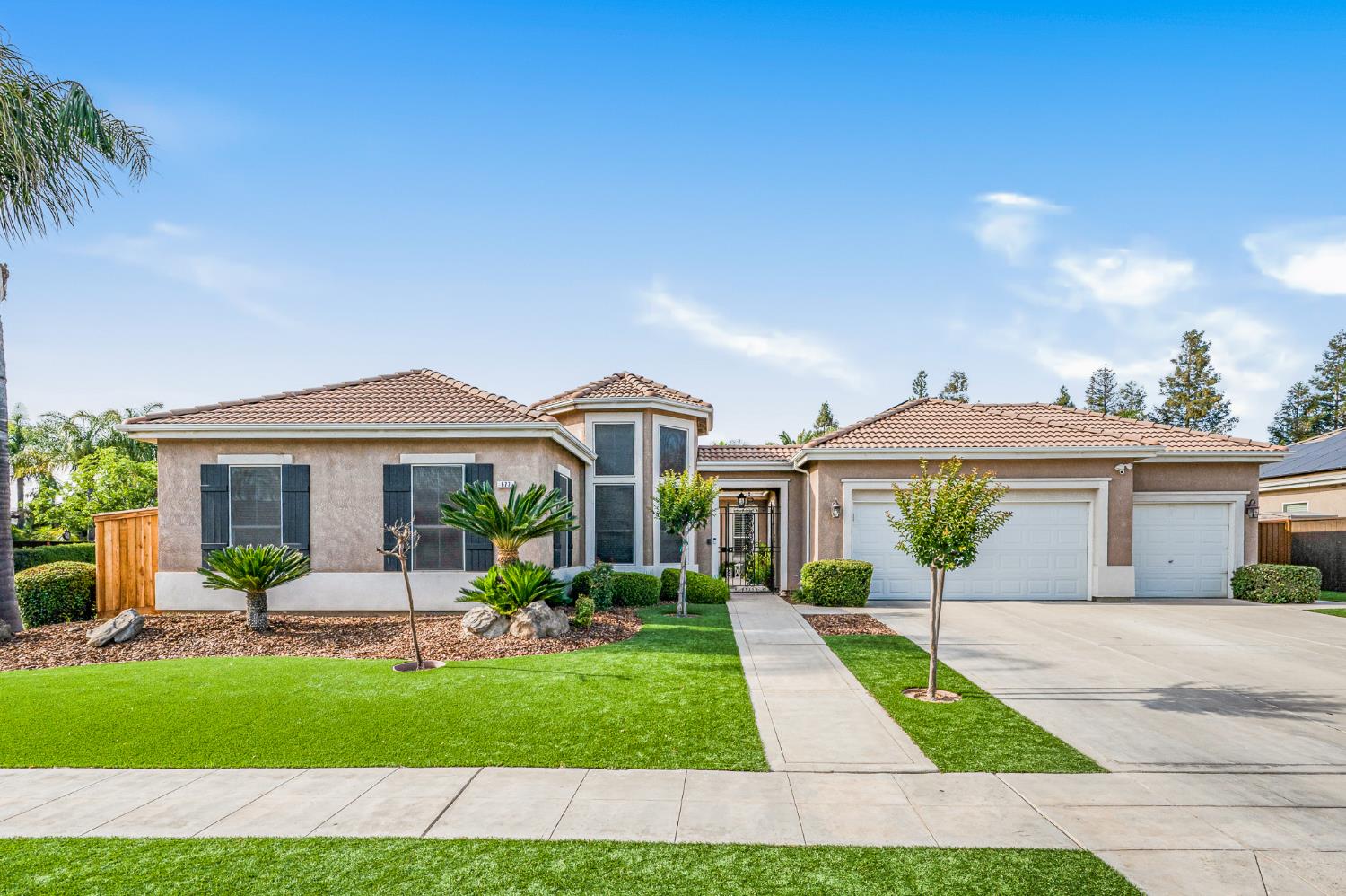 a front view of a house with a yard and potted plants