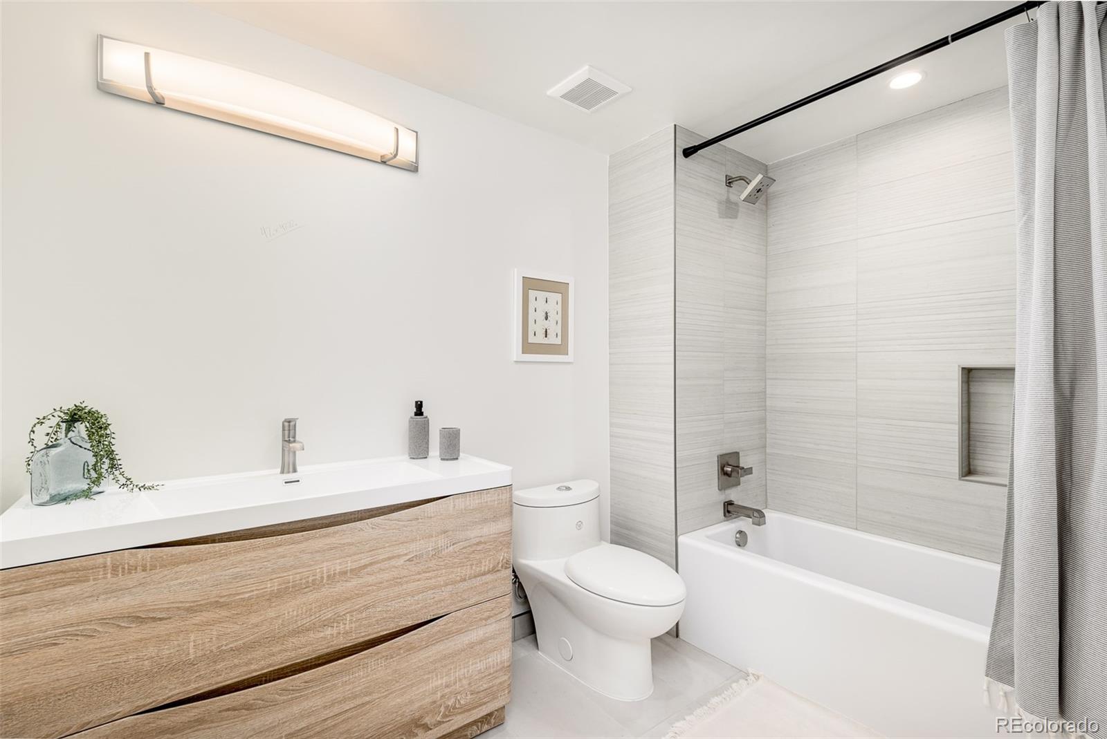 4461 Utica Street Denver, CO 80212 - Photo 35 of 40 a bathroom with a sink a toilet and a bathtub