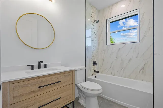 a bathroom with a toilet a sink a mirror and bathtub