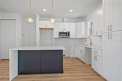 a kitchen with kitchen island a sink stainless steel appliances and cabinets