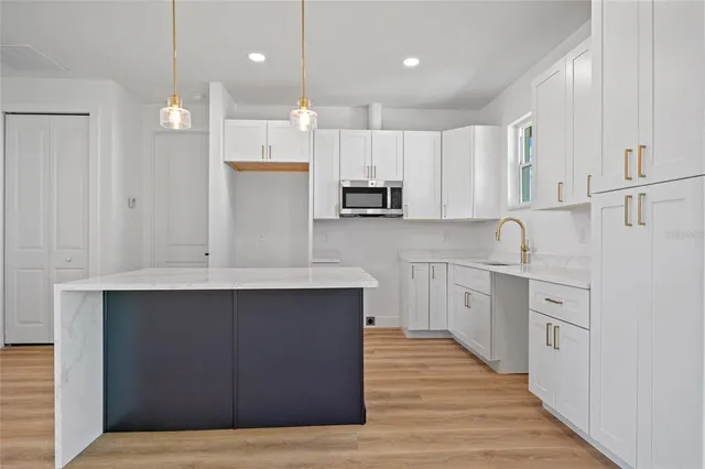 a kitchen with kitchen island a sink stainless steel appliances and cabinets