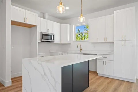 a kitchen with a sink a microwave and cabinets