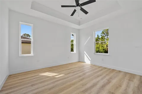 a view of empty room with wooden floor and window