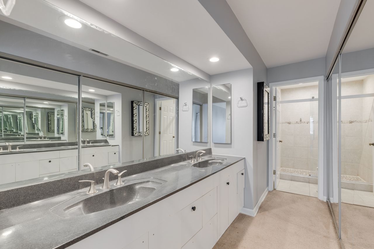 938 Hidden Lake Drive, Unit 938 Buffalo Grove, IL 60089 - Photo 11 of 16 a spacious bathroom with a double vanity sink shower and mirror