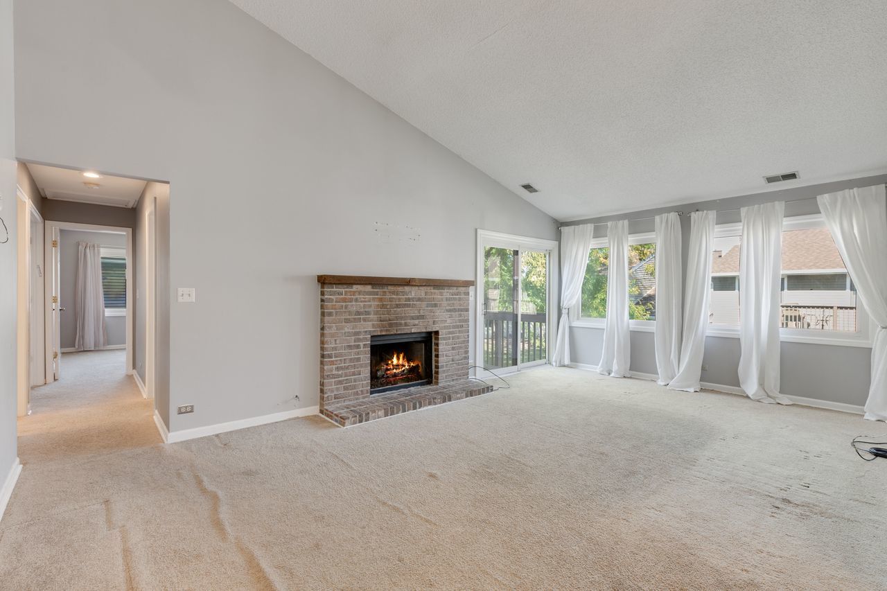 938 Hidden Lake Drive, Unit 938 Buffalo Grove, IL 60089 - Photo 2 of 16 a view of an empty room with a fireplace and a window