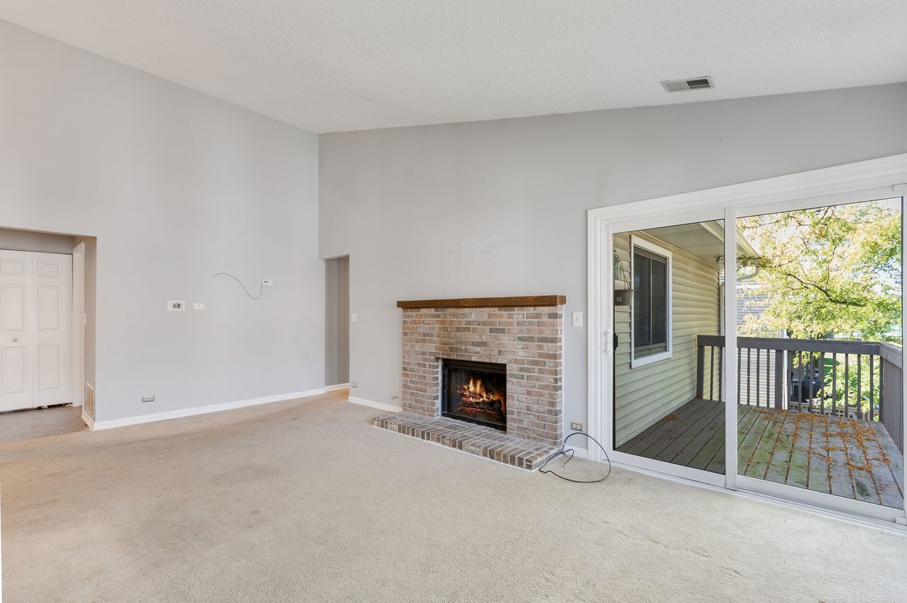 938 Hidden Lake Drive, Unit 938 Buffalo Grove, IL 60089 - Photo 3 of 16 an empty room with fireplace and windows