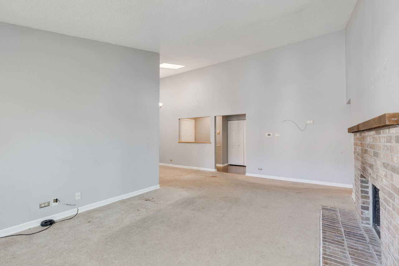 938 Hidden Lake Drive, Unit 938 Buffalo Grove, IL 60089 - Photo 4 of 16 an empty room with a fireplace