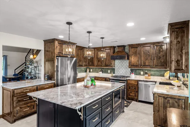 a kitchen with stainless steel appliances granite countertop a sink stove and refrigerator