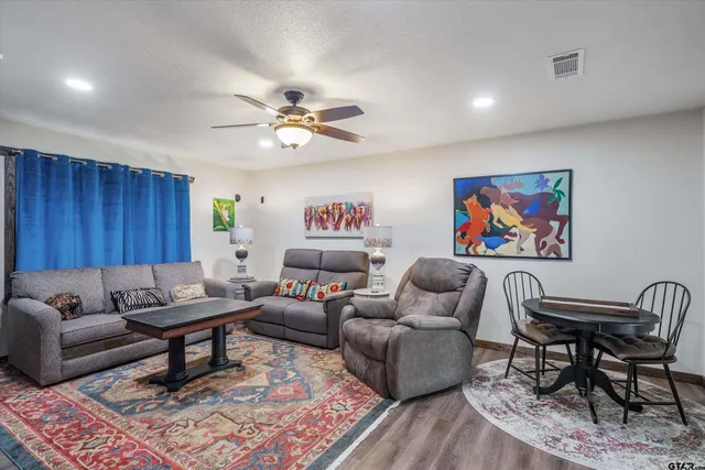 a living room with furniture a rug and a flat screen tv