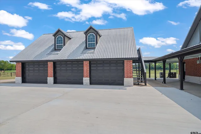 a front view of a house with yard and parking