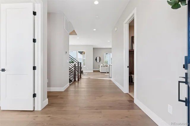 a view of hallway with stairs and wooden floor