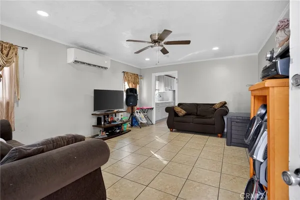 a living room with furniture and a flat screen tv with kitchen view