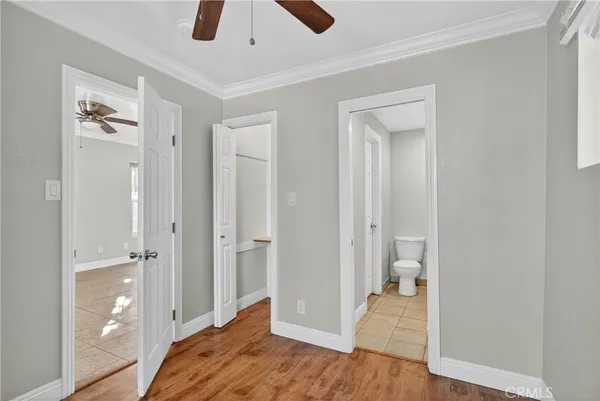 a view of a room with wooden floor and a ceiling fan