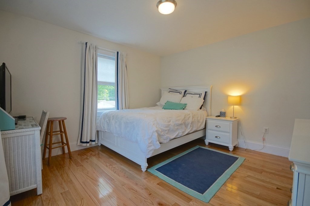 13 Warren Street Needham, MA 02492 - Photo 29 of 34 a bedroom with a bed and a flat tv screen on a dresser