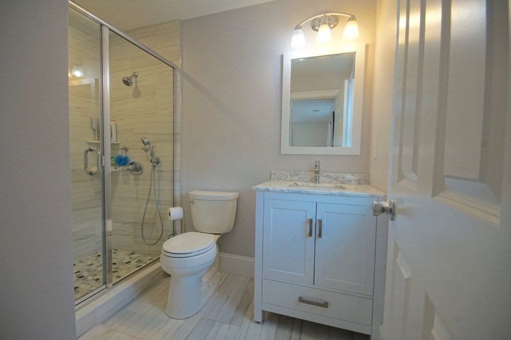 13 Warren Street Needham, MA 02492 - Photo 30 of 34 a bathroom with a granite countertop sink toilet and shower