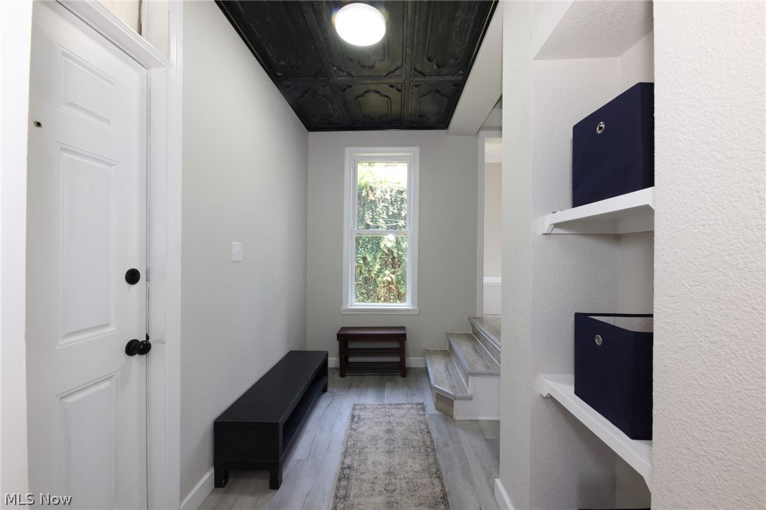 416 5th Street Chester, WV 26034 - Photo 2 of 24 Entryway featuring wood-finish flooring, a white paneled door with black hardware, and a window providing natural light