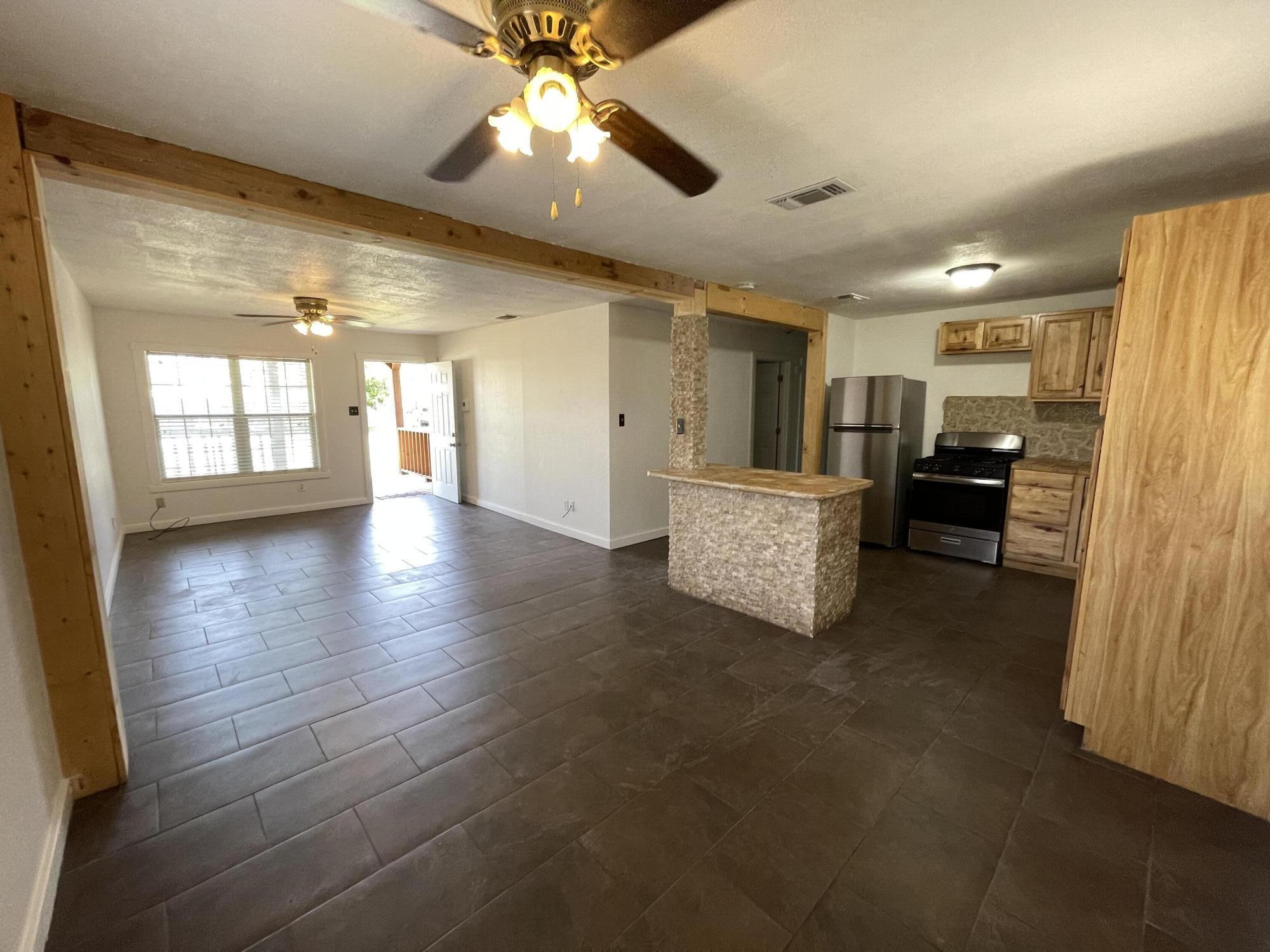 4813 37th Street Lubbock, TX 79414 - Photo 2 of 12 a view of a big room with chandelier fan and windows