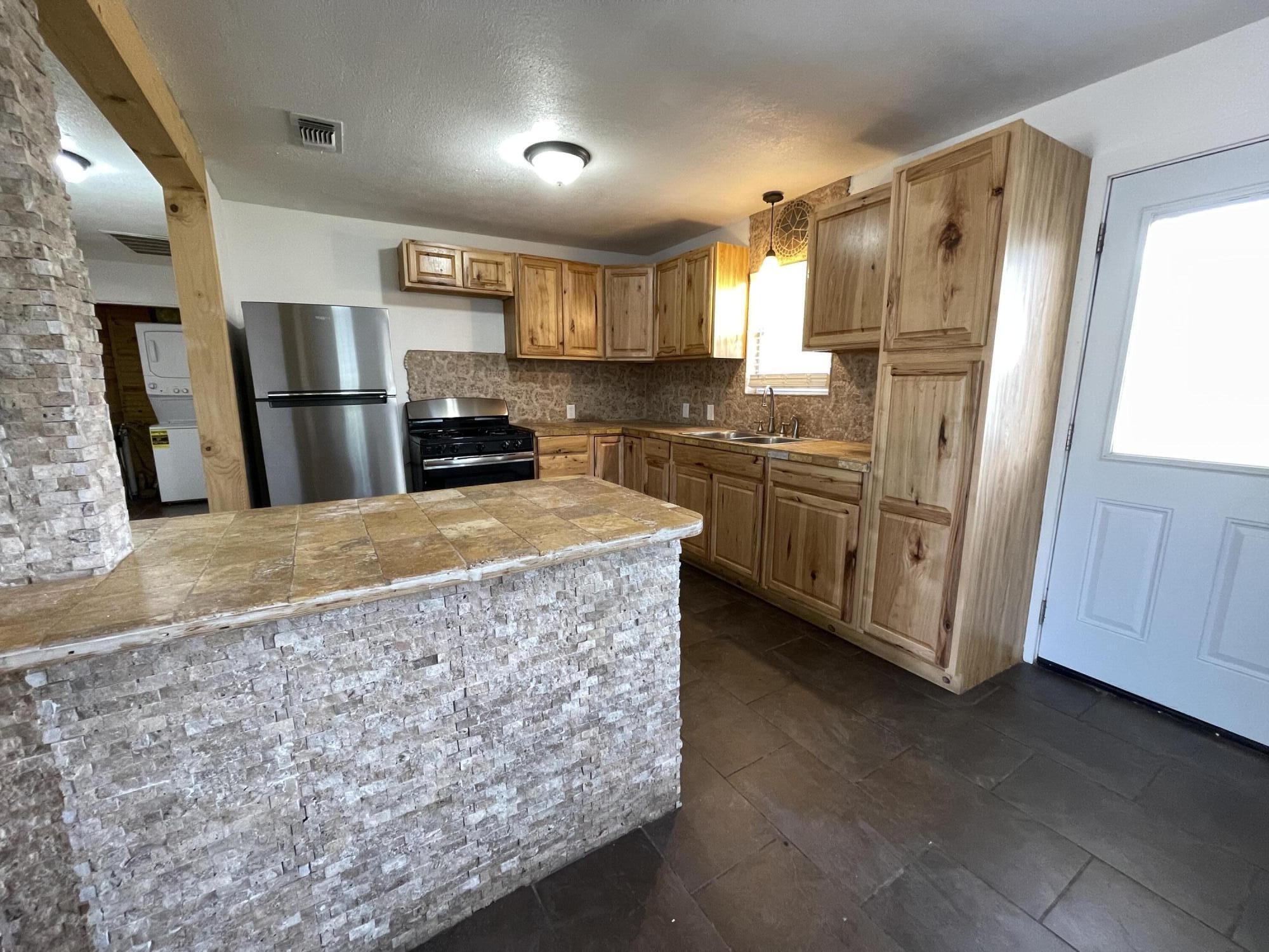 4813 37th Street Lubbock, TX 79414 - Photo 4 of 12 a kitchen with stainless steel appliances granite countertop a refrigerator a stove a sink and a refrigerator