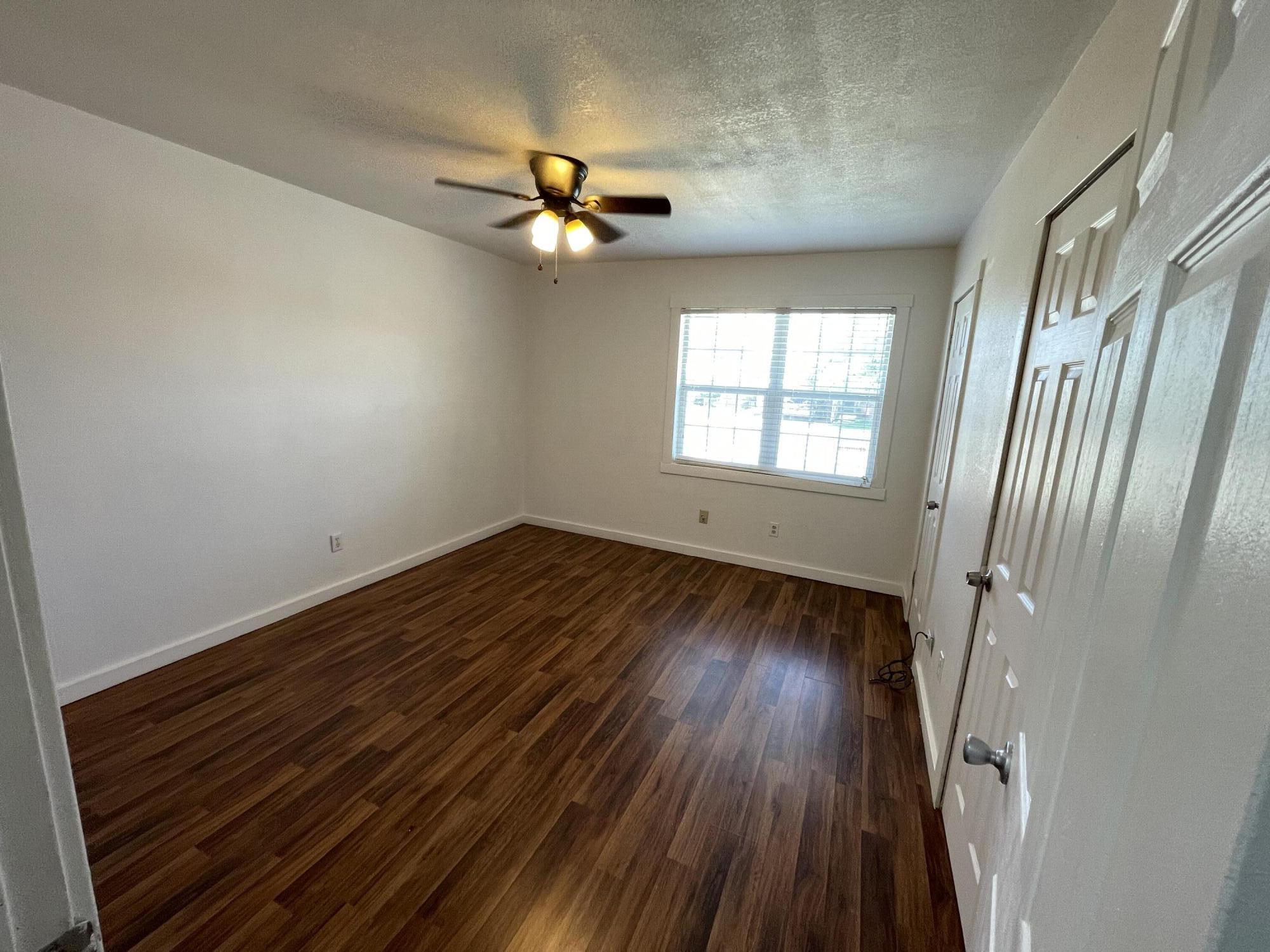 4813 37th Street Lubbock, TX 79414 - Photo 7 of 12 an empty room with wooden floor fan and windows