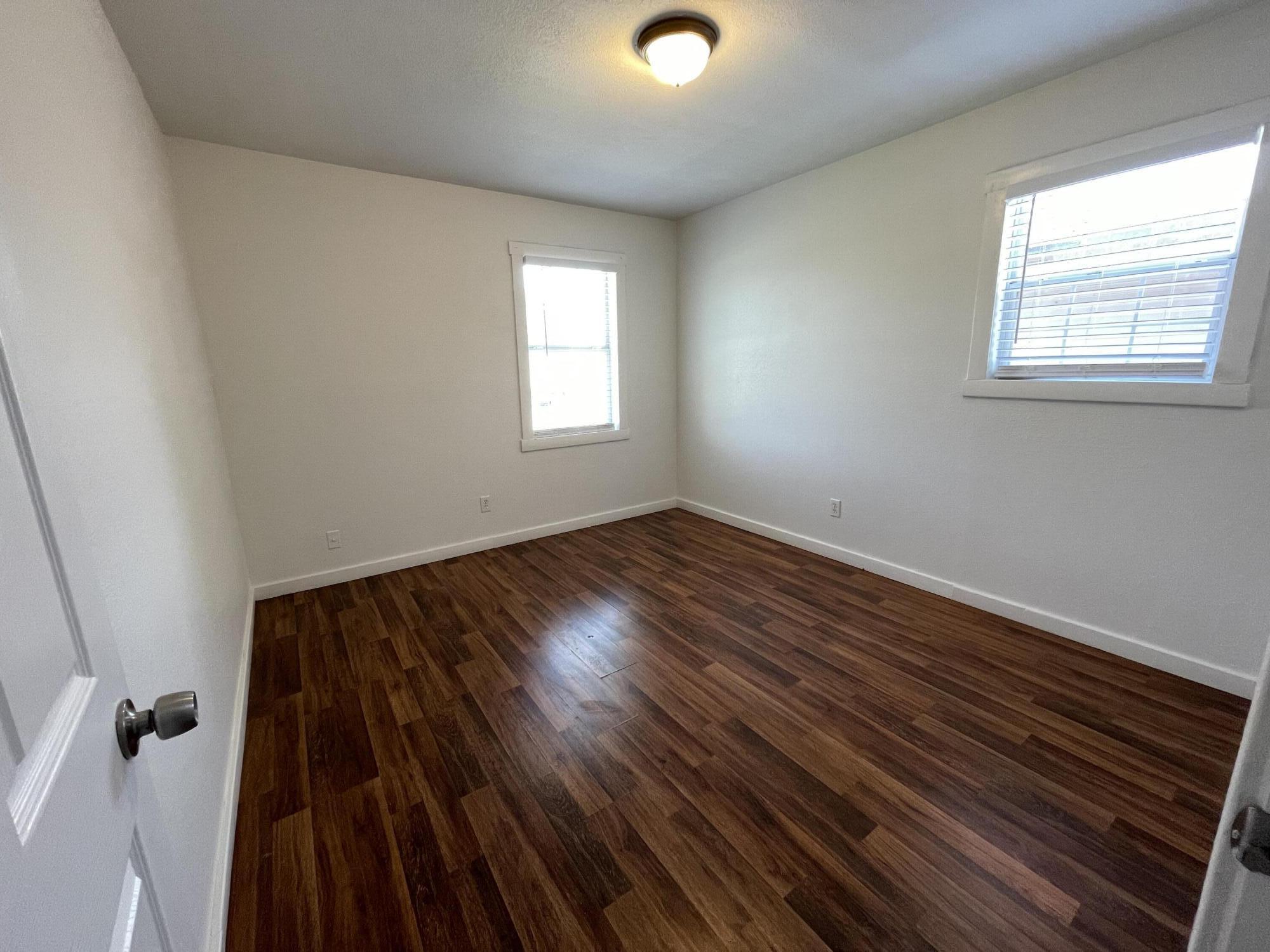 4813 37th Street Lubbock, TX 79414 - Photo 8 of 12 an empty room with wooden floor and windows