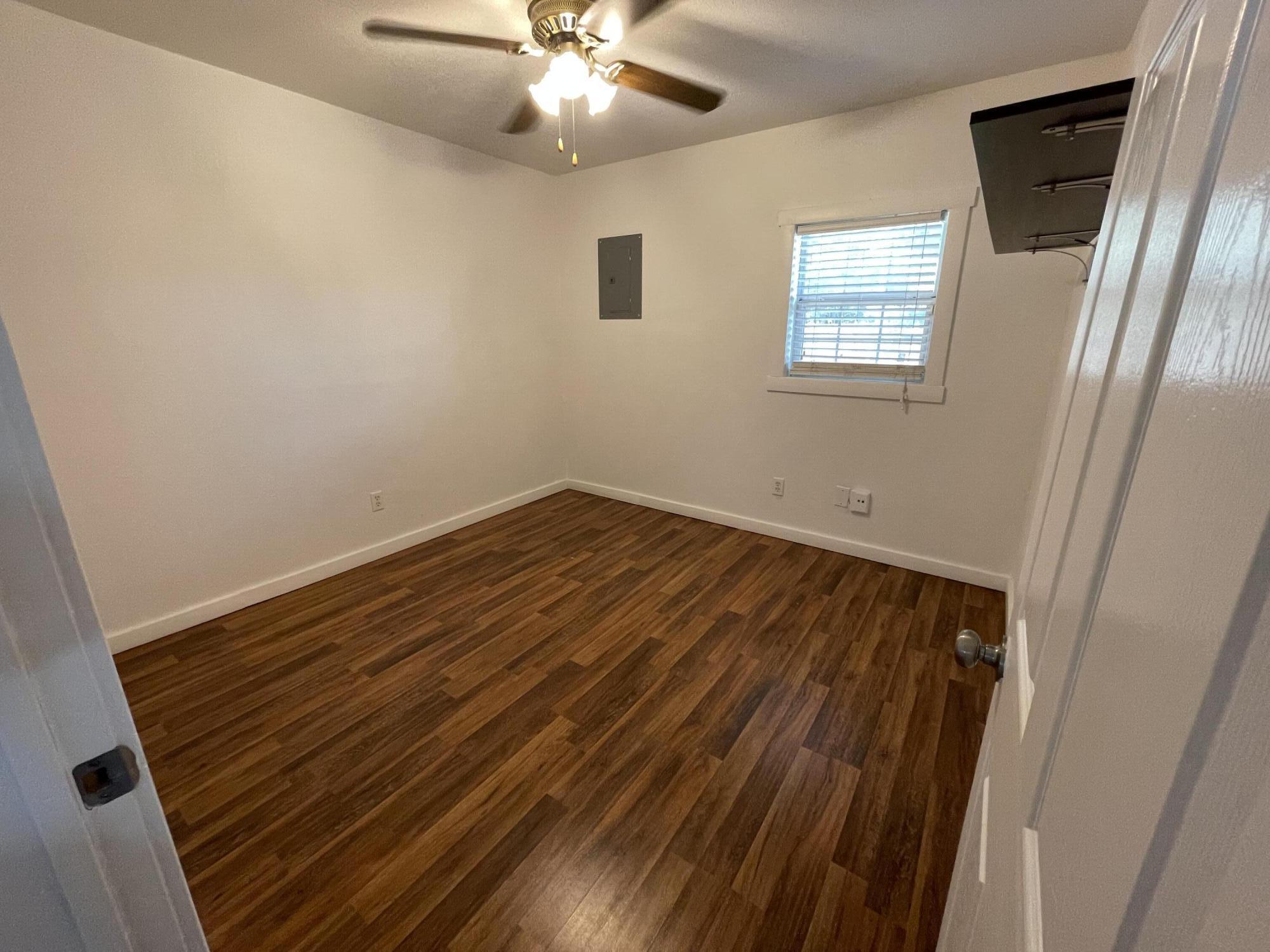4813 37th Street Lubbock, TX 79414 - Photo 9 of 12 an empty room with wooden floor fan and windows