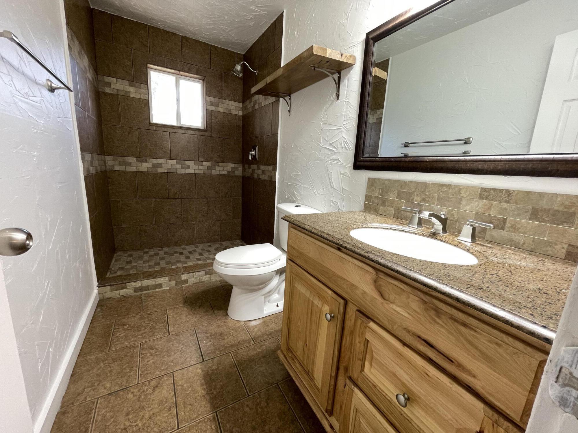 4813 37th Street Lubbock, TX 79414 - Photo 10 of 12 a bathroom with a granite countertop sink toilet and shower